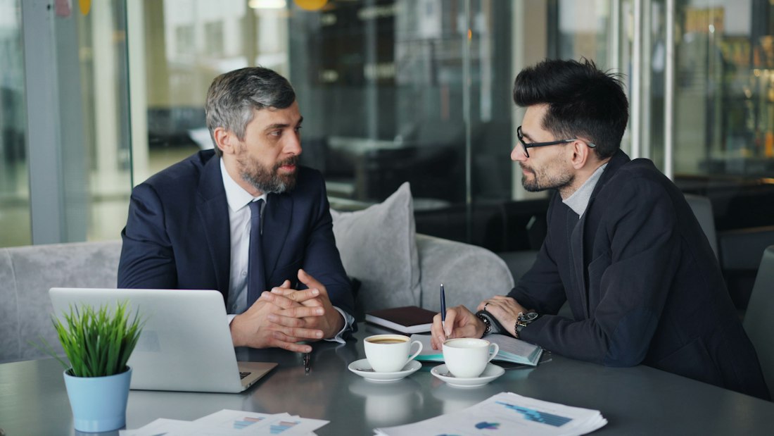 Two professionals in a focused conversation at a table