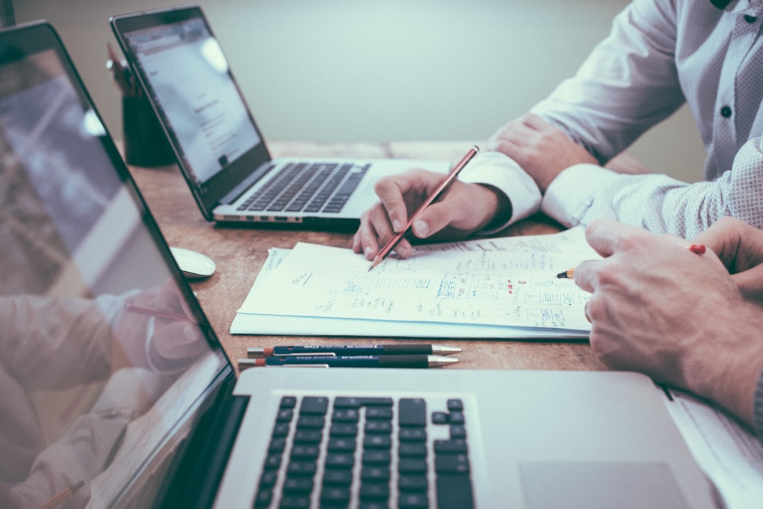 Business owner reviewing financial notes beside a laptop