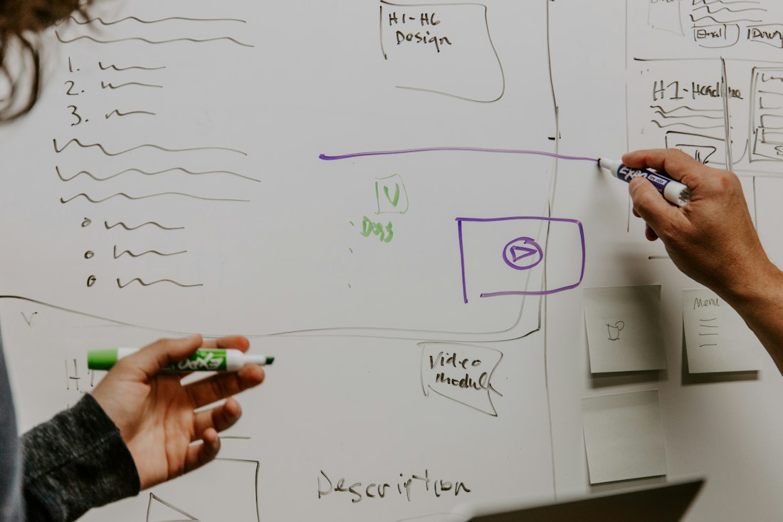 Two founders sketching a business model on a whiteboard