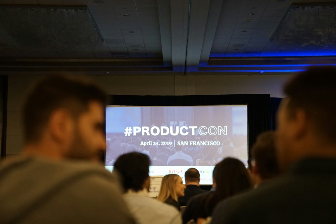 Audience watching a startup pitch presentation on a large screen
